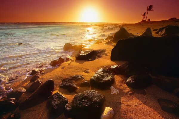 A sultry sunset. Ocean shore in rocky rocks