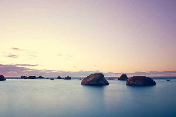 Sunset on the background of the sea and rocks