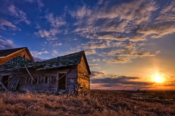 An old house on the background of the sunset sky