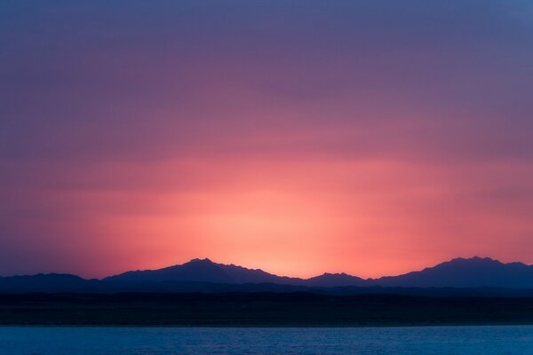 Purple sunset and silhouettes of mountains