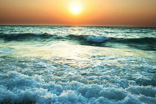 Der abendliche Sonnenuntergang spiegelt sich im tosenden Meer wider