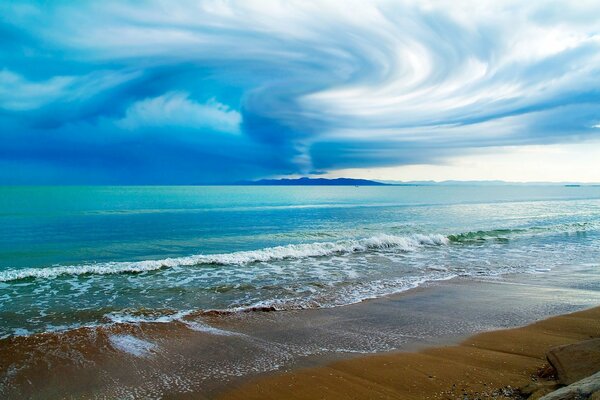 The sandy shore of the azure ocean