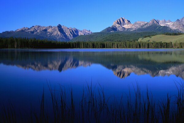 Lago blu in cui si riflettono le montagne