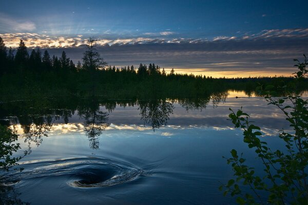 Le lac reflète le ciel bleu et le coucher du soleil