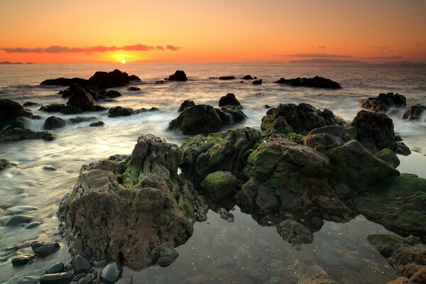 Stones by the sea on the background of sunset