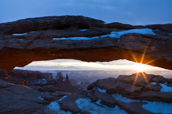 Die Sonnenstrahlen erhellen den schneebedeckten Canyon