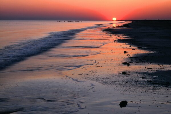 Tramonto del sole rosso sulla spiaggia