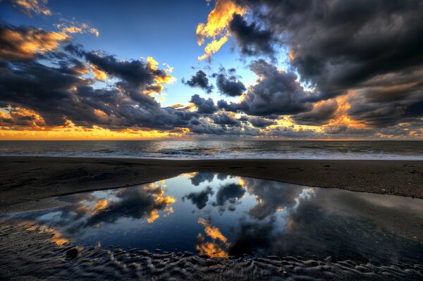 Reflexion des Himmels und des Sonnenuntergangs im Meer