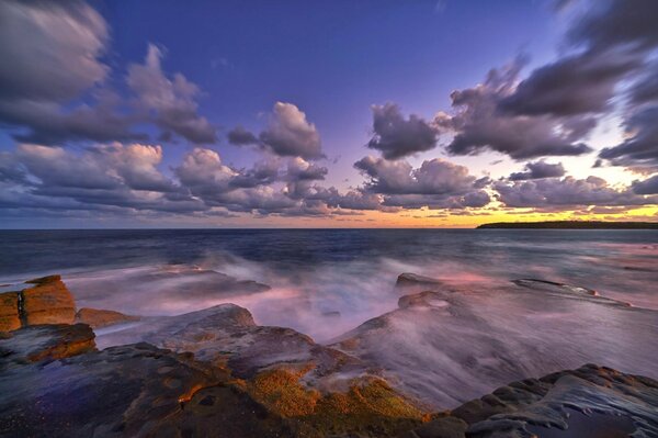 Côte de pierre de la mer et le ciel coucher de soleil avec des nuages