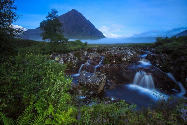 Cascada de montaña al amanecer en Escocia