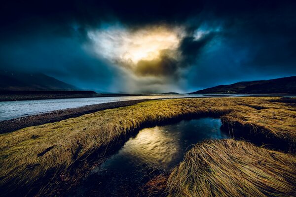 Nächtlicher Fluss und dichte Wolken