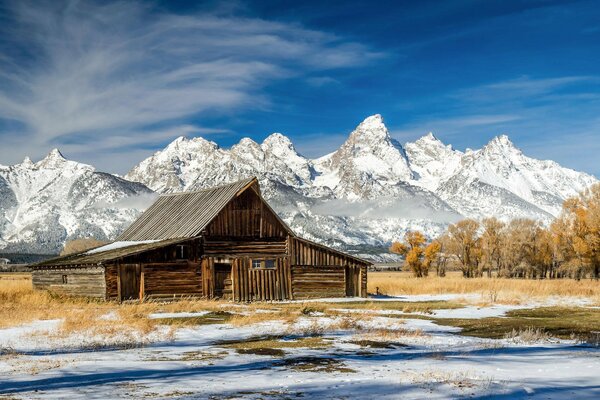 Alte Hütte vor dem Hintergrund der schneebedeckten Berge