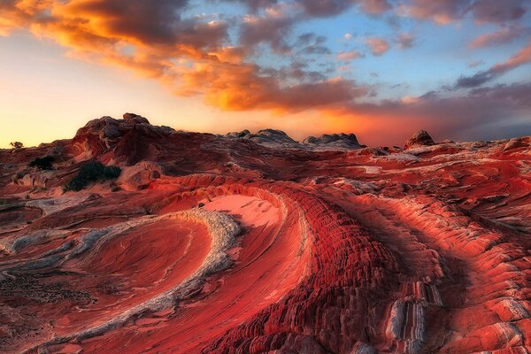 Rote wellenförmige Berge vor dem Hintergrund eines rilligen blauen Himmels