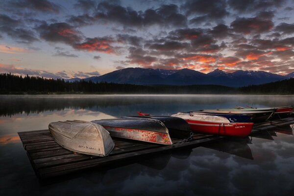 Overturned boats on lake pier at sunset