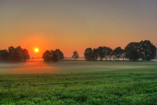 Le coucher du soleil illumine la vallée brumeuse