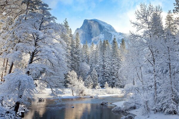 Winter landscape. The river at the snow-capped mountain