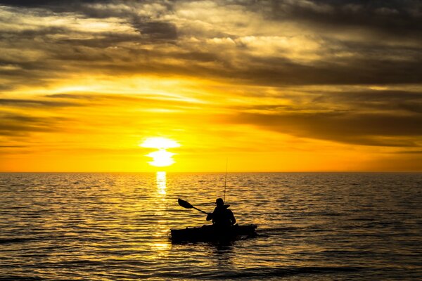 Fischerboot auf dem Hintergrund des Flusses Sonnenuntergang