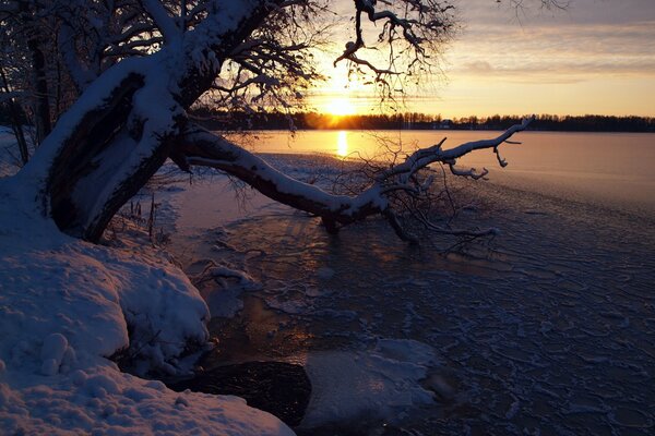 Sunset by a snowy river