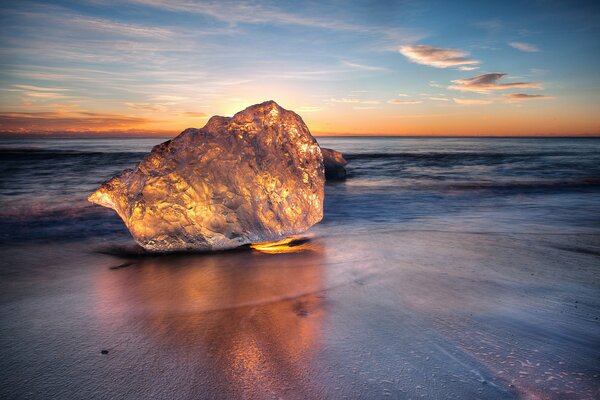 The ocean shore in the sunset rays of the sun