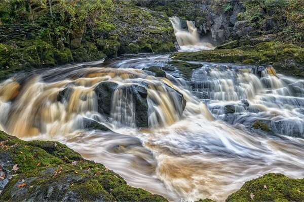 The small waterfall breaks on the rocks