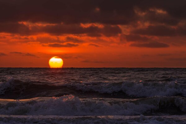 Puesta de sol roja sobre la superficie del mar