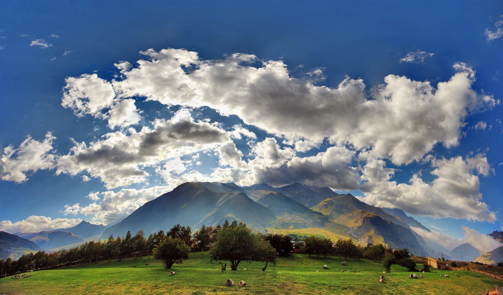 géorgie nuages ciel champ herbe montagnes kazbegi village