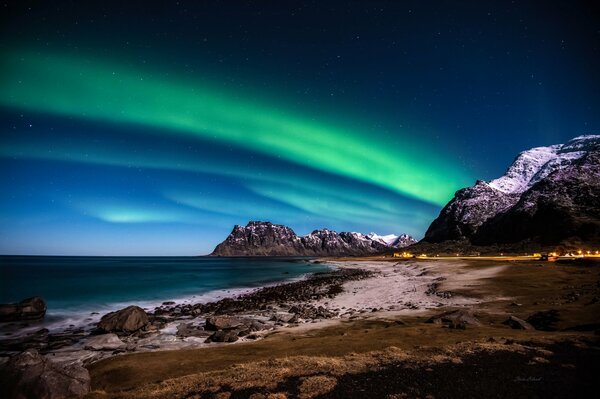 Nordlichter am Meer vor dem Hintergrund der Berge