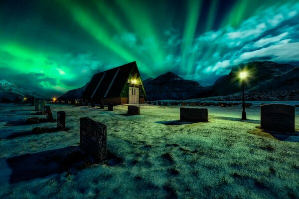 Nordlicht in der Nacht vor dem Hintergrund des Friedhofs