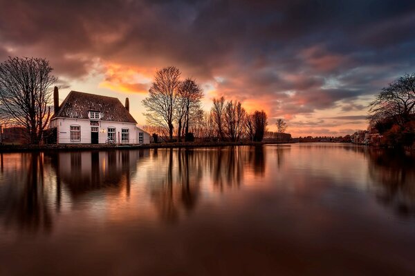 Das Haus am Flussufer spiegelt sich im Wasser wider