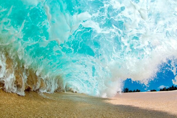 Vague capturant le sable sur la plage