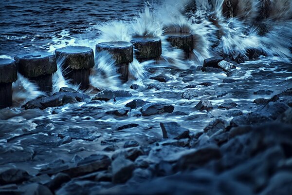 Olas del mar sobre piedras en el puerto