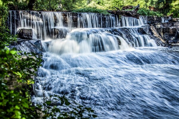 Photo de qualité d une cascade sur fond de paysage vert