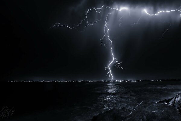 Foudre dans le ciel nocturne, près de la mer