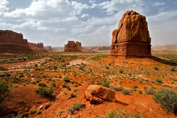 Cloudy sky. Rocks. Green on orange ground