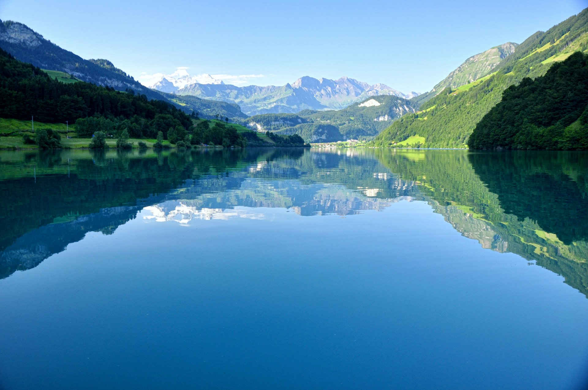 svizzera lago lungern coste foresta alberi montagne alpi cime cielo riflessione