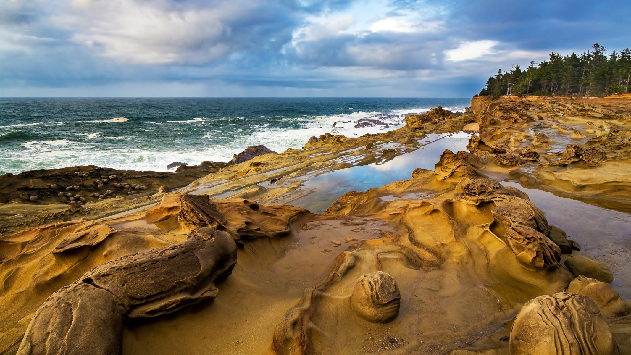 costa rocce acqua onde alberi cielo nuvole