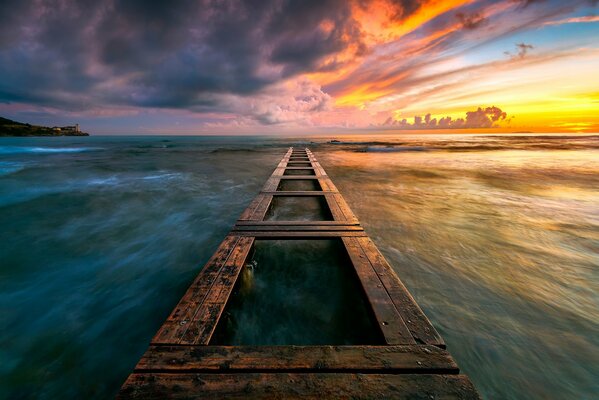 Puesta de sol en el mar con muelle