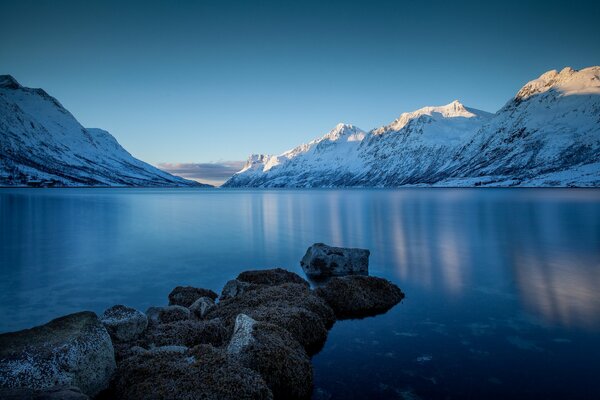 Landscape of a winter lake with a rocky shore