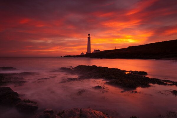 The beach against the background of a lighthouse standing in the distance