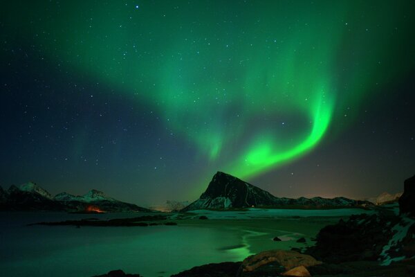 Aurores boréales dans la nuit dans les montagnes près du lac