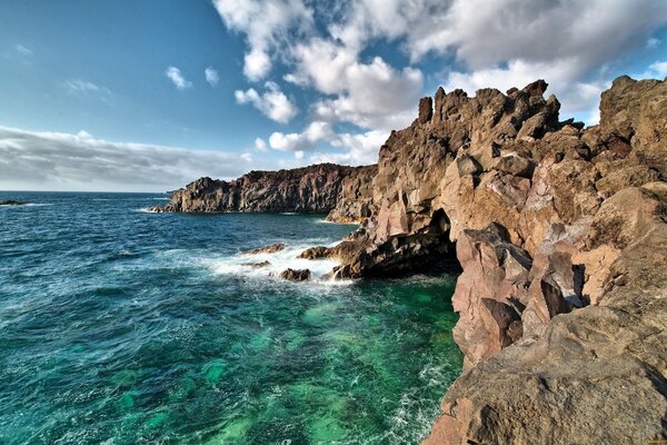 Beautiful ocean coast with mountains and clouds in the sky