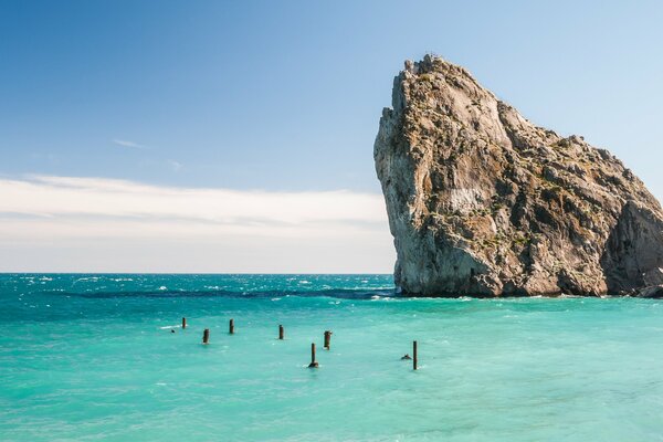 Una roca que sale del mar azul