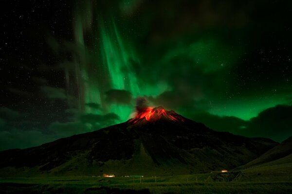 Erupción volcánica bajo la Aurora boreal