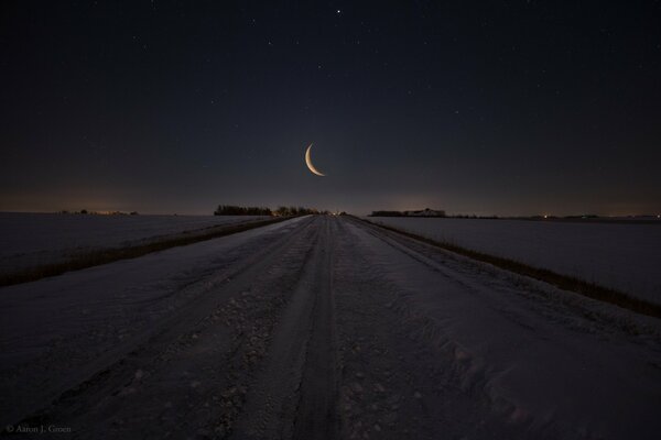 Landscape month over a snow-covered road