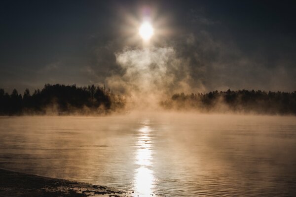 Alba sul lago nella nebbia fredda