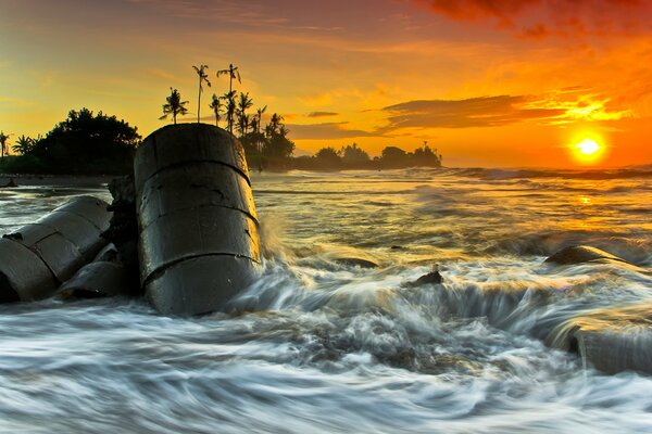 Barrels in the sea on the background of sunset