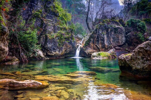 Paysage de lac parmi les rochers avec cascade