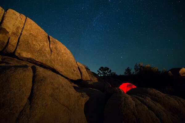 Red tent among the mountains at night