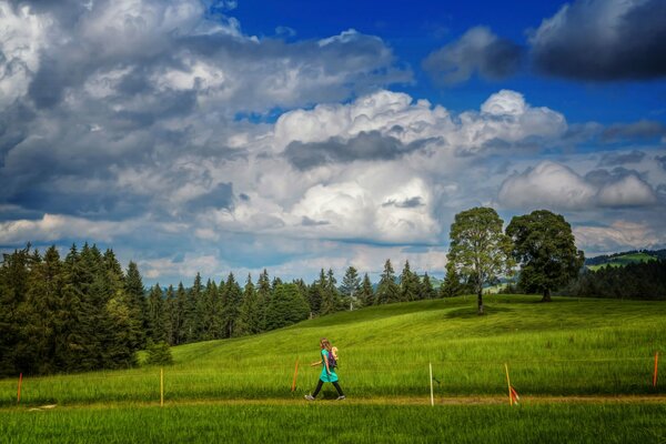 A girl walks along a green path