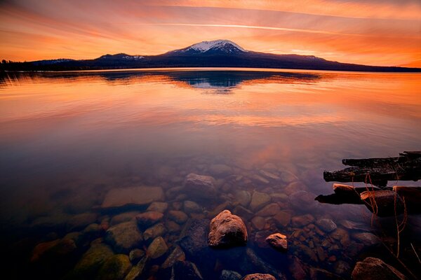 Sonnenuntergang über einem transparenten Bergsee